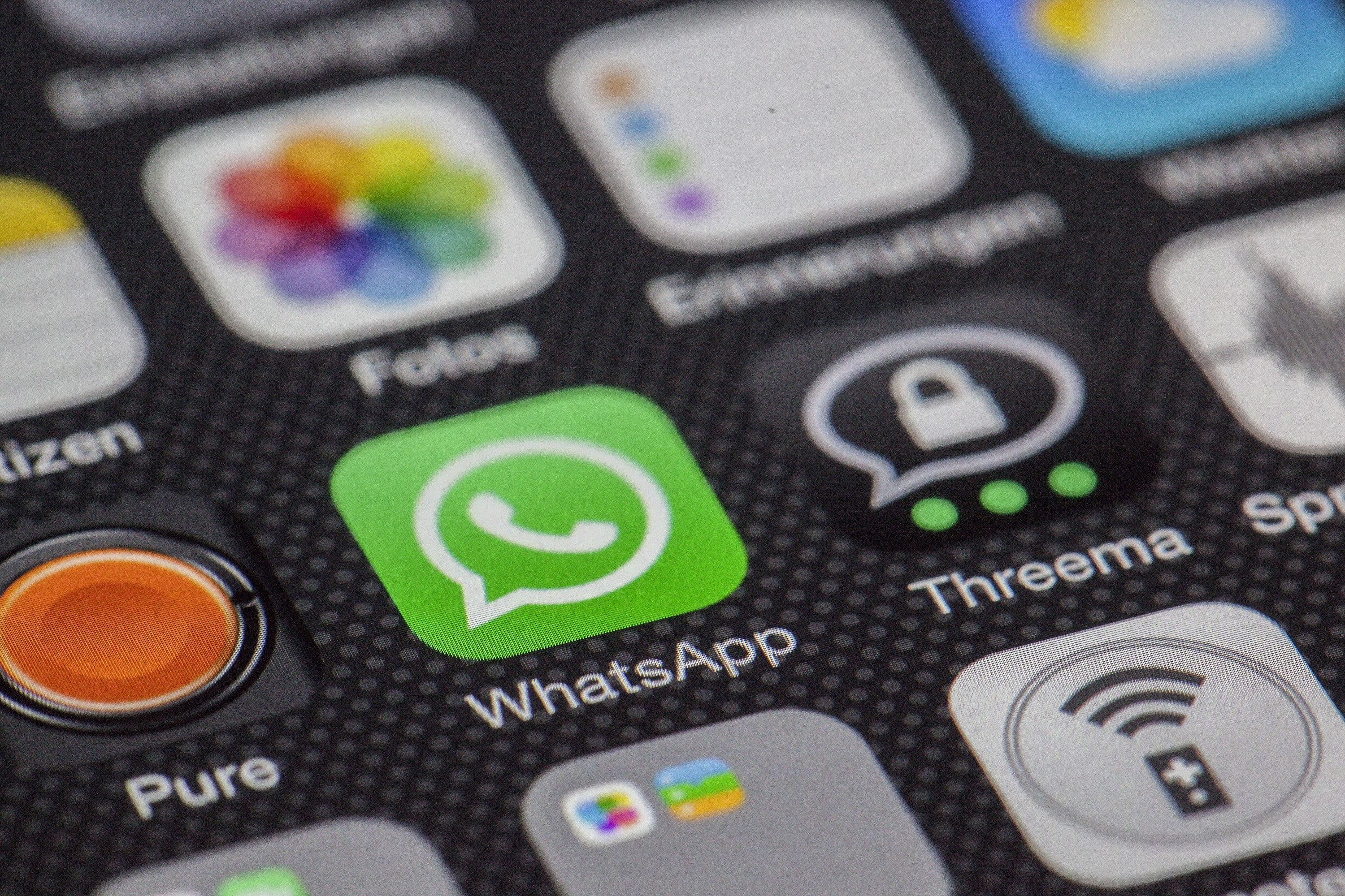 Pessoa segurando celular com WhatsApp aberto